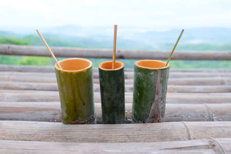 bamboo tube for drinking water with beauty nature backgroundの写真素材