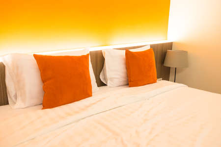 Orange pillow on hotel bed