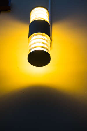 Orange light from the lamp on the wall in homeの写真素材