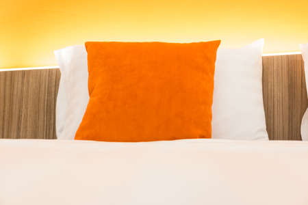 Orange pillow on white bedroomの写真素材