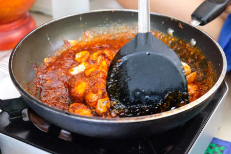 Chef cooking Thai style food with mushroom in pan