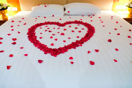 Wedding bed topped with rose petals, Thai style weddingの写真素材