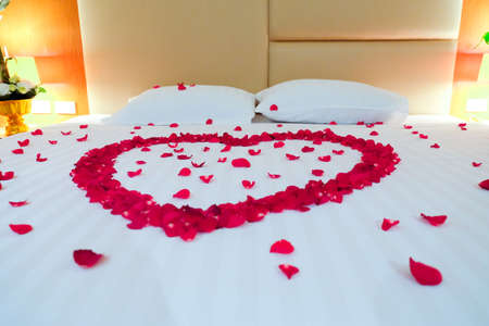 Wedding bed topped with rose petals, Thai style weddingの写真素材
