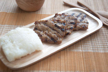 grilled pork with sticky rice on wood plateの写真素材