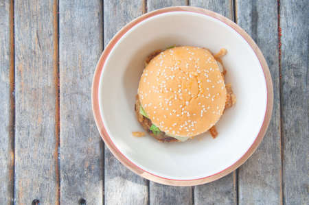 Top view BBQ burger on white dish on wooden background