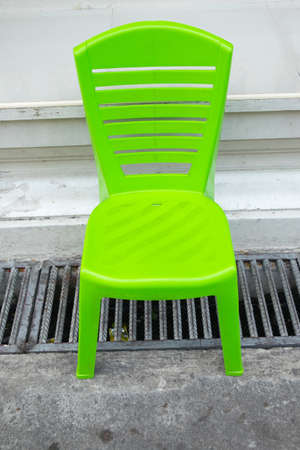 One empty green plastic chairの写真素材