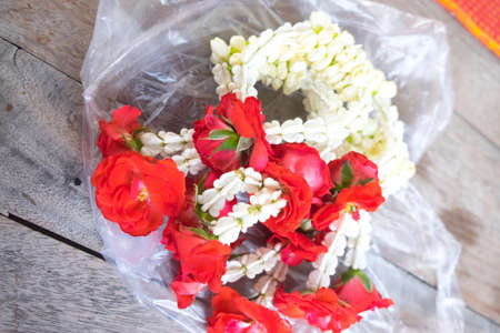 Flower garlands for Buddha on wood table, Thailandの写真素材