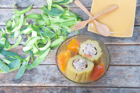 Stuffed bitter gourd with minced pork in clear soup sereved in glass bowl on wooden background.の写真素材