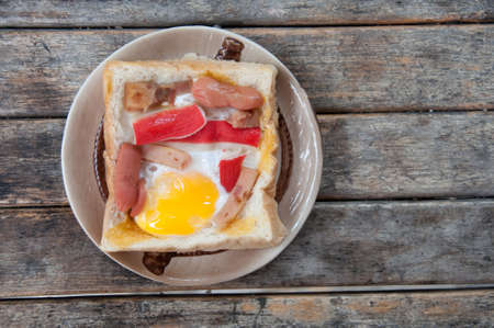 Egg in a hole is breakfast menu of American on wood tableの写真素材