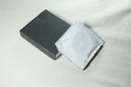 Condom with silver condom packages on bedの写真素材