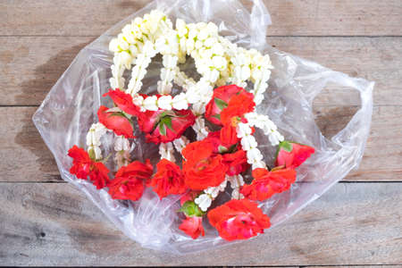 Flower garlands for Buddha on wood table, Thailandの写真素材