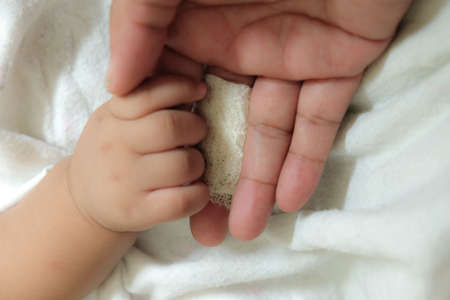 concept of love and family. injury hand finger take care by babyの写真素材