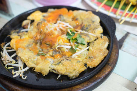 Oysters fried in egg batter on iron pan (cooking) - Thailand food Pan - fried crispy mussel with bean sprout, Crisp fried oyster pancakeの写真素材