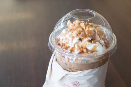 Iced coffee latte topped with whipped cream and caramel sauceの写真素材