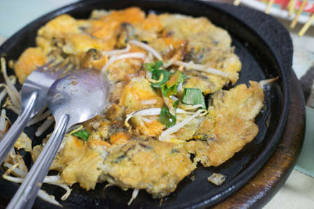 Oysters fried in egg batter on iron pan (cooking) - Thailand food Pan - fried crispy mussel with bean sprout, Crisp fried oyster pancakeの写真素材