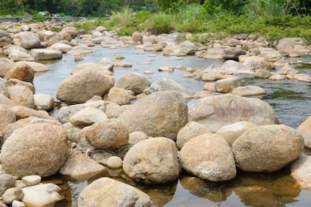 Small stream over rocks with a grass bank in Khiriwong Sichon ,Nakhon Si Thammarat, Thailandの写真素材