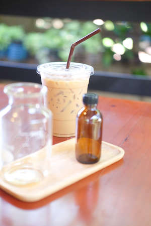 Iced coffee with straw in plastic cup on tableの写真素材