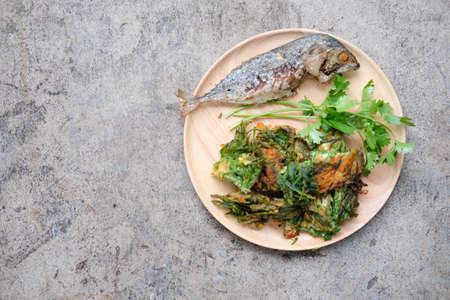 Fried Acacia Pennata, Climbing Wattle with egg and fried mackerel  on wood plate (cha-om kai in Thai)の写真素材