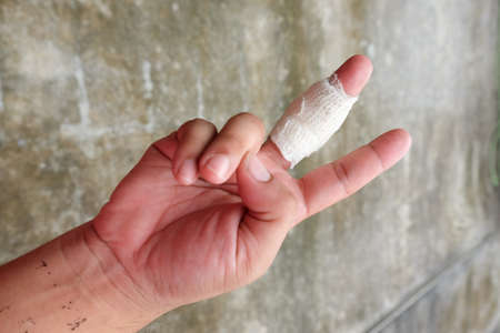 Close up of finger must have wound with gauze bandageの写真素材