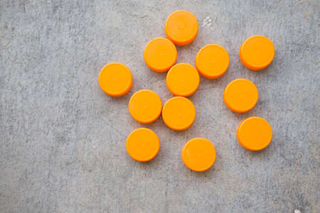 Orange plastic bottle caps on stone backgroundの写真素材