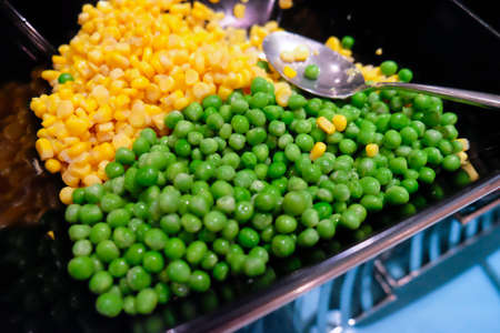 Peas and corn in tray at buffetの写真素材