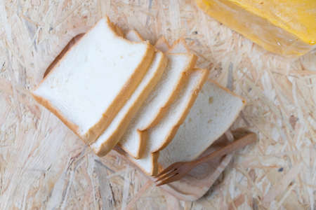 Sliced white bread top view on wood background