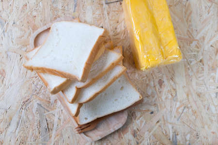 Slice of bread and butter on wood tableの写真素材