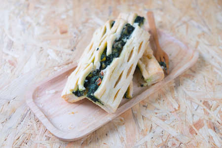 Healthy pastry with spinach on wood trayの写真素材