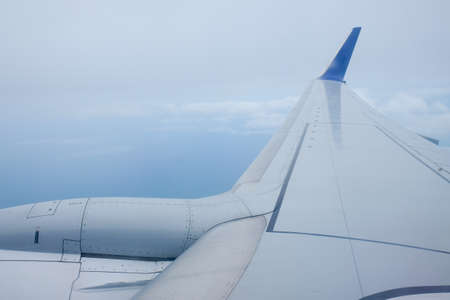 viewpoint Wing of windows airplane flying above the clouds in the sky