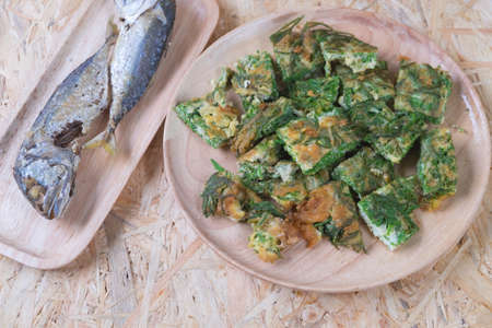 Fried acacia pennata omelet with fried mackerel on wood dishの写真素材