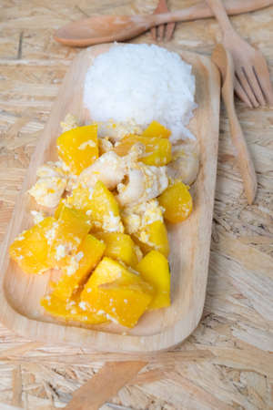 Stir fried pumpkin with egg and pork on wood trayの写真素材