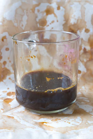 Espresso coffee in glass cup on coffee stains background