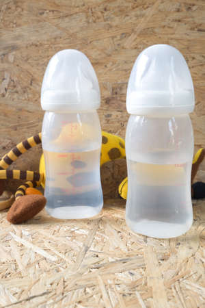 Two empty baby bottles on wood table