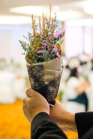 Beautiful bouquet of wild flowers in the hands of manの写真素材