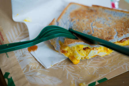 Eating sandwich with scrambled eggsの写真素材