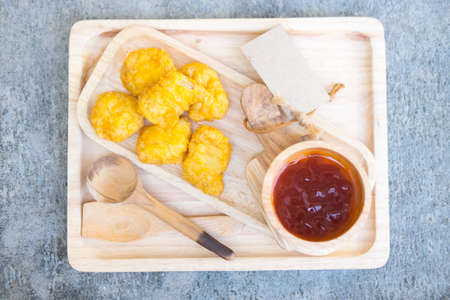 Tasty homemade chicken nuggets with ketchup on wood plateの写真素材