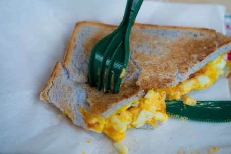Eating sandwich with scrambled eggsの写真素材