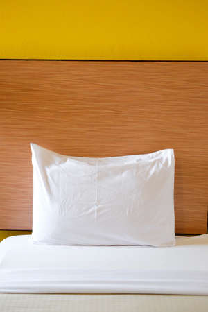 White bedding sheets and pillow with wood backgound