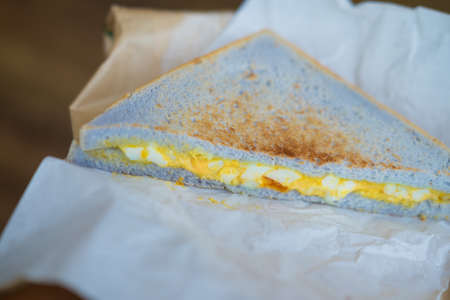 Eating sandwich with scrambled eggs