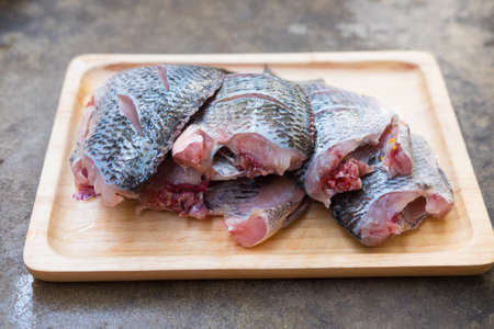 Fresh fish tilapia on wooden trayの写真素材
