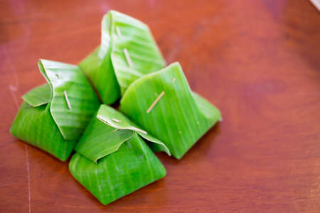 Thai dessert sticky rice with steamed custard wrapped in banana leaves.の写真素材