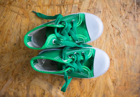 a little boy sneakers shoes on wood backgroundの写真素材