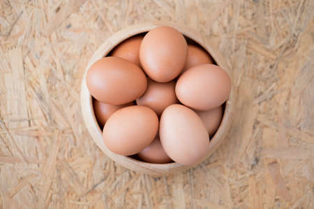 Top view of fresh eggs in wooden bowlの写真素材