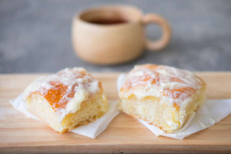 Fresh bread with icing and butter and hot tea or hot coffeeの写真素材