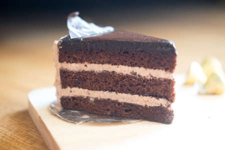 Slice of chocolate cream cake on wood table, selective focusの写真素材