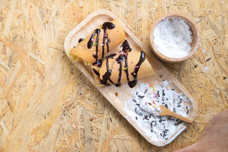 Kanom Tokyo is a thin flat pancake or crepe filled with sweet custard cream and topping with sauce chocolate and icingの写真素材