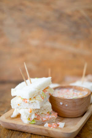 Sandwiches with coleslaw fillings and coleslaw salad on wood tray, selective focusの写真素材