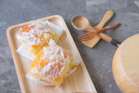 Fresh homemade bread sprinkle with butter and sugar on wooden trayの写真素材