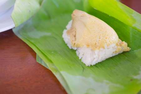 Thai dessert Sticky rice with steamed custard wrapped in banana leafの写真素材