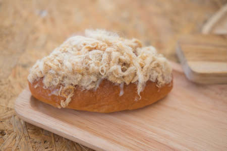 Bun with sweet dried pork on top in wood trayの写真素材
